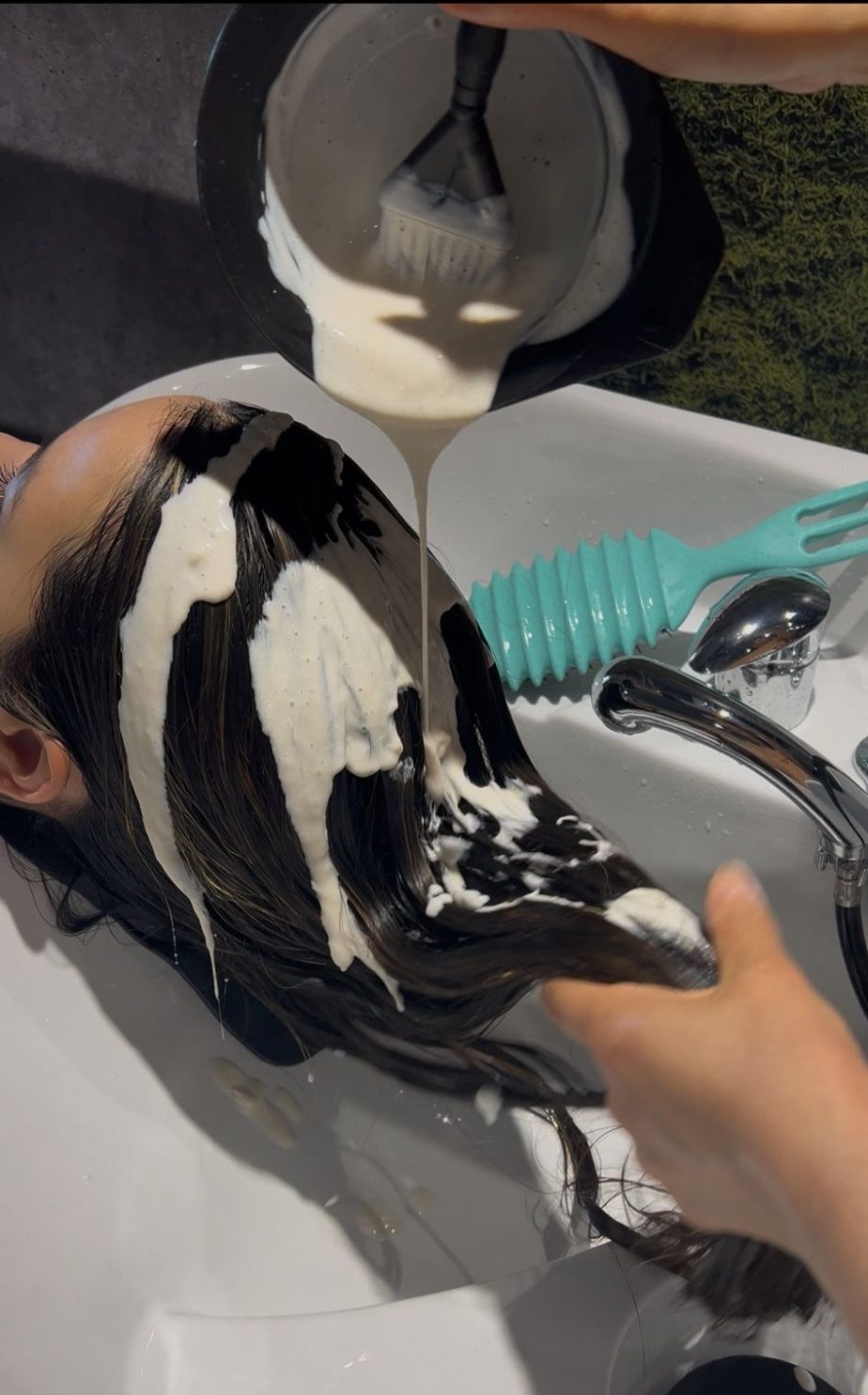 Bild, wo gerade eine Pflegespülung aus den Haaren gewaschen wird.